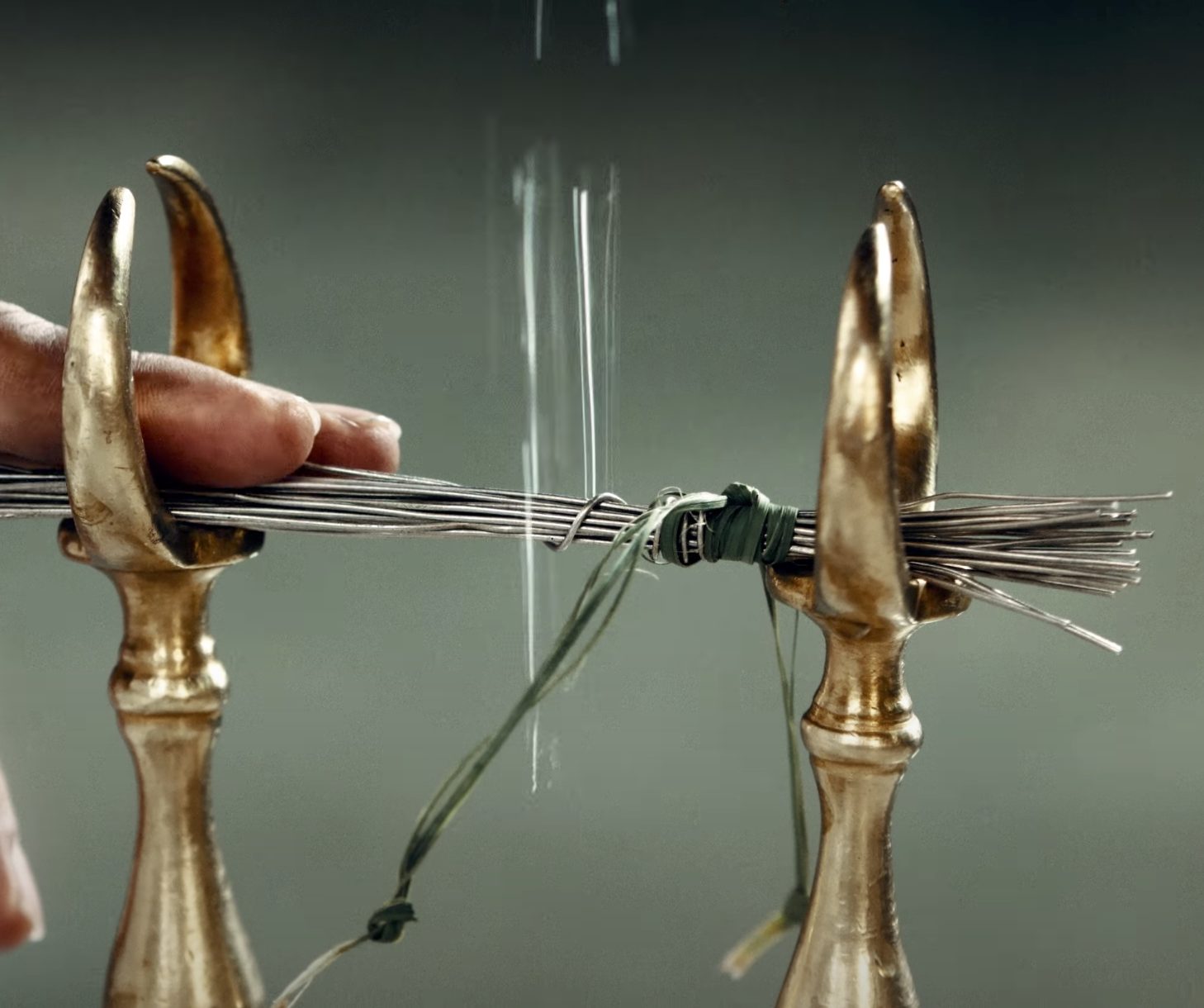 Close-up of ritual implements: the barsom bundle held between metal stands